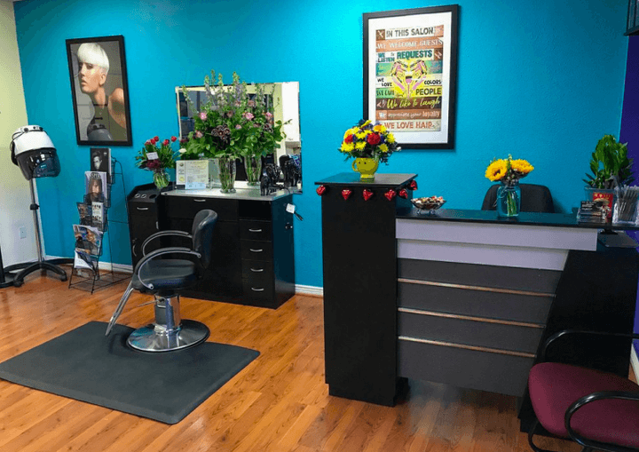 A stylist holding up a mirror so a smiling client can see her new hair